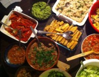 ingredients for veggie fajitas: onion and pepper strips, tofu strips, rice, refried beans, mole, guacamole, salsa